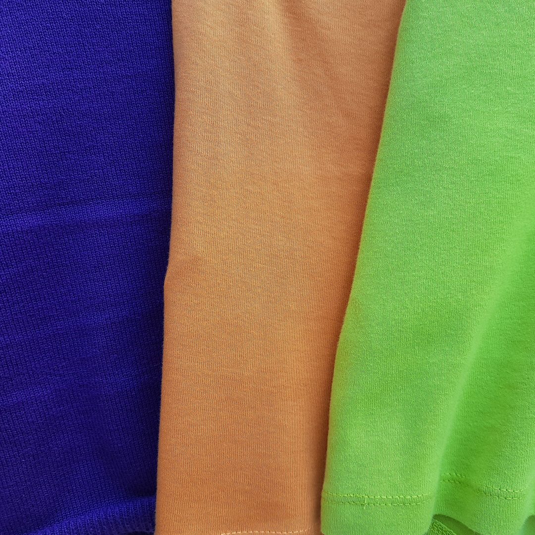 Foto van drie kledingstukken met felle kleuren bij het gedicht "Combineren" van Marianne Nan.